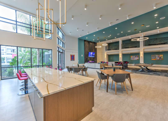 a large lobby with tables and chairs and a reception desk  at Pinnacle Apartments, Jacksonville, 32256