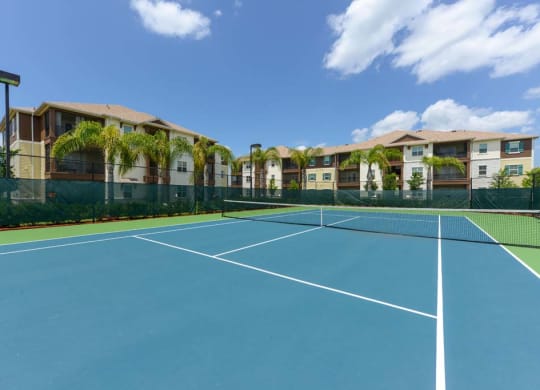 a tennis court in front of an apartment complex  at Cabana Club - Galleria Club, Jacksonville, FL, 32256