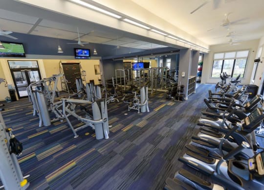 a large fitness room with cardio equipment and flat screen tvs  at Cabana Club - Galleria Club, Jacksonville, Florida