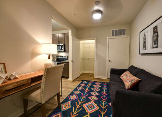 a living room with a couch and chair in front of a desk with a lamp and a  at Fusion, Jacksonville, Florida