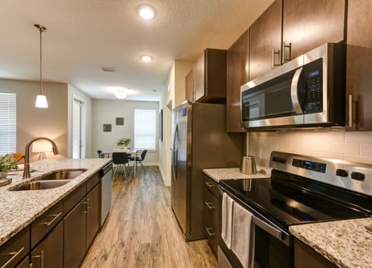 a kitchen with a stove top oven next to a sink  at Fusion, Florida, 32256