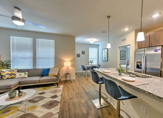 a living room and kitchen area with a couch and a table  at Fusion, Jacksonville, FL