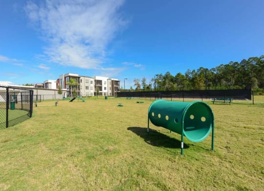 a large grassy area with a playground and buildings in the background  at Luxor Club, Jacksonville, FL