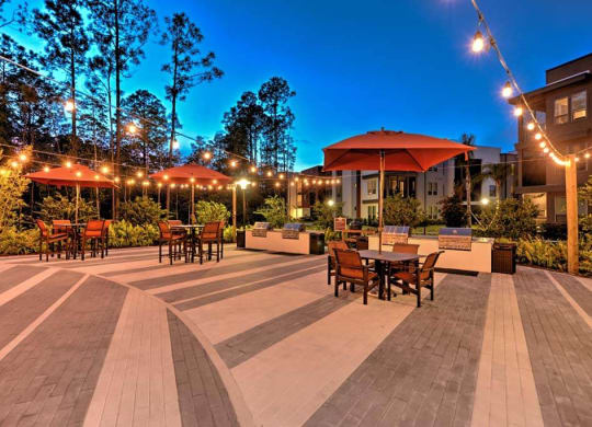 a patio with tables and umbrellas at night  at Luxor Club, Jacksonville, Florida