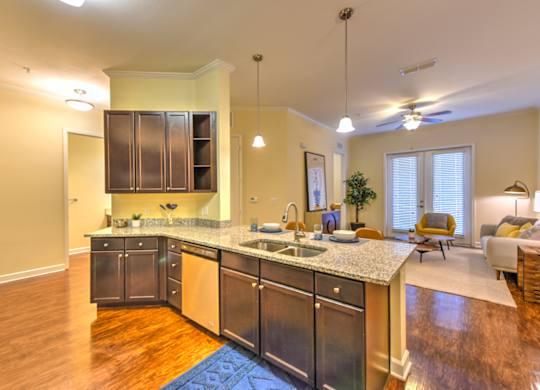 A kitchen with a granite countertop and stainless steel appliances at Alaqua, Florida, 32258