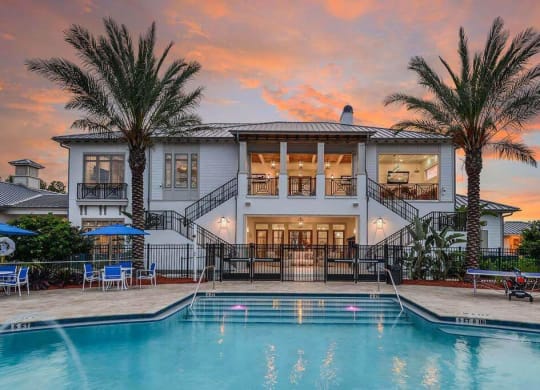 a large white house with a pool in front of it  at Palm Bay Club, Florida, 32258