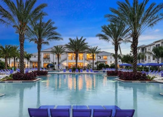 a large pool with a bunch of palm trees in front of a building  at Palm Bay Club, Jacksonville