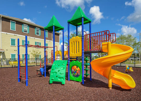 a playground with a slide and other toys in front of a building  at Cabana Club - Galleria Club, Jacksonville, Florida
