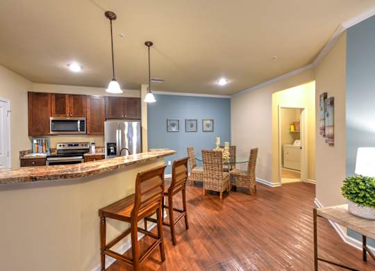 A kitchen with wooden chairs and a counter at Cabana Club - Galleria Club Apartments, Jacksonville, 32256