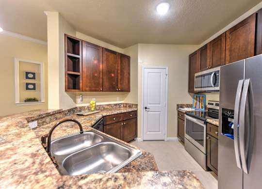 A kitchen with a granite counter top and stainless steel appliances at Cabana Club - Galleria Club Apartments, Jacksonville, FL, 32256