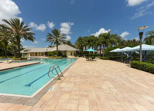 A large outdoor swimming pool surrounded by palm trees at Cabana Club - Galleria Club Apartments, Jacksonville, FL, 32256