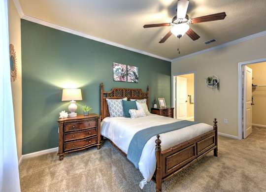 A bedroom with a bed, dresser, and ceiling fan at Cabana Club - Galleria Club Apartments, Jacksonville, Florida