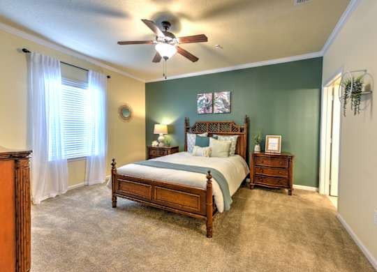 A bedroom with a bed, dresser, and window at Cabana Club - Galleria Club Apartments, Jacksonville, FL, 32256