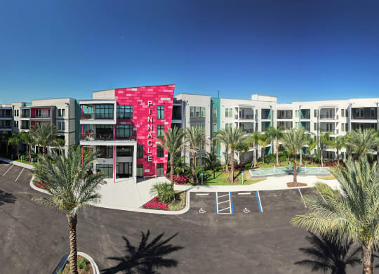 a building with palm trees in front of it at Pinnacle Apartments, Jacksonville, FL
