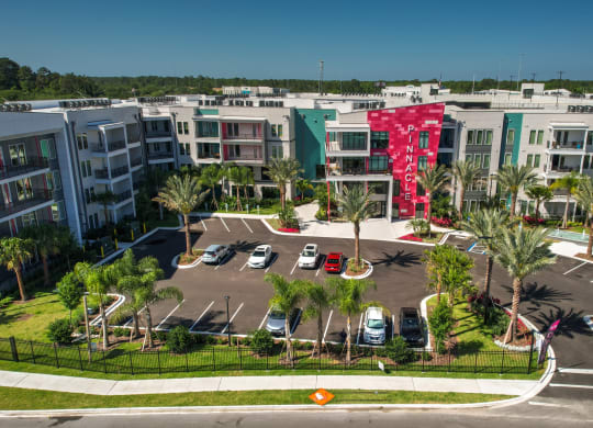an aerial view of an apartment complex with parking lot and palm trees at Pinnacle Apartments, Florida, 32256