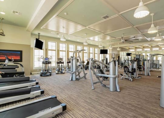 a spacious fitness center with cardio equipment and a flat screen tv  at Palm Bay Club, Jacksonville, Florida