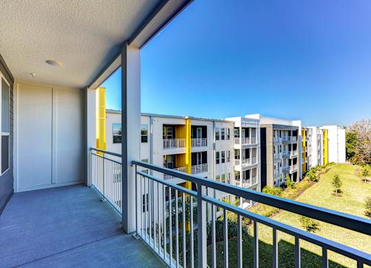 A balcony with a metal railing and a view of apartment buildings at Fusion Apartments, Jacksonville, FL