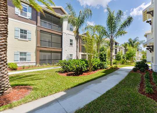 A row of apartment buildings with a sidewalk in front at Cabana Club - Galleria Club Apartments, Jacksonville