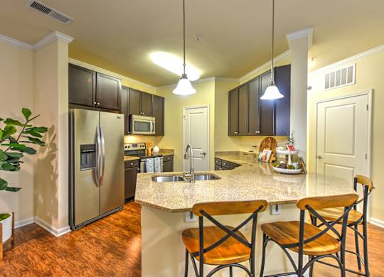 A kitchen with a refrigerator, microwave, oven, sink, and cabinets at Cabana Club - Galleria Club Apartments, Florida