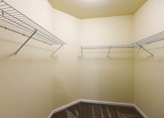 A walk-in closet with a metal rack and a carpeted floor at Cabana Club - Galleria Club Apartments, Florida 32256
