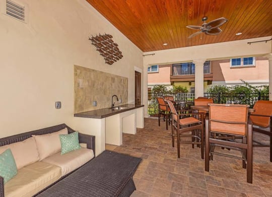 a living room with a couch a table and a ceiling fan  at Hacienda Club, Jacksonville, FL