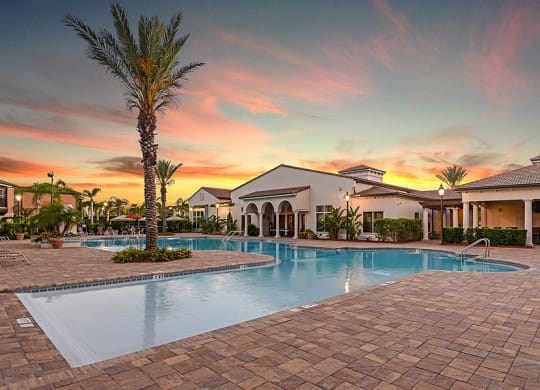 a home with a swimming pool in front of a sunset  at Hacienda Club, Jacksonville, 32256