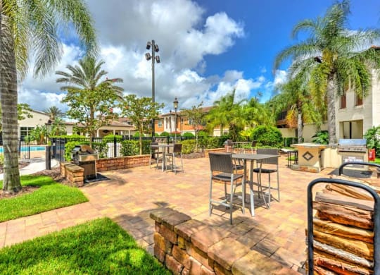 a patio with tables and chairs and a pool in the background  at Hacienda Club, Jacksonville