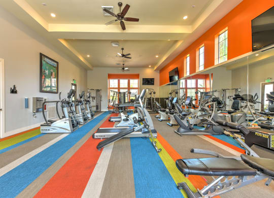a gym with treadmills and other exercise equipment in a large room with windows at Hacienda Club, Jacksonville