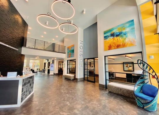 a lobby with a blue chair and a yellow wall  at Fusion, Jacksonville, FL, 32256