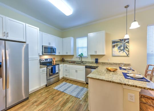 a kitchen with white cabinets and stainless steel appliances at Palm Bay Club, Jacksonville, FL