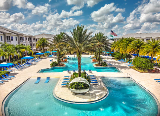 a large swimming pool with a fountain in the middle and a hotel in the background at Palm Bay Club, Jacksonville, 32258
