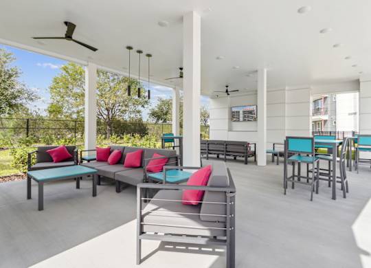 A patio with a table and chairs with a fan in the backgroundat Pinnacle Apartments, Jacksonville, FL