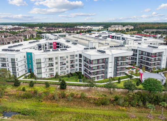 A large white building complex with a red roofat Pinnacle Apartments, Jacksonville, FL