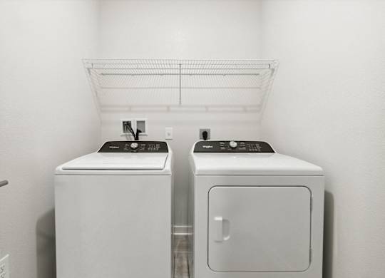 A white bathroom with a washer and dryerat Pinnacle Apartments, Jacksonville, FL