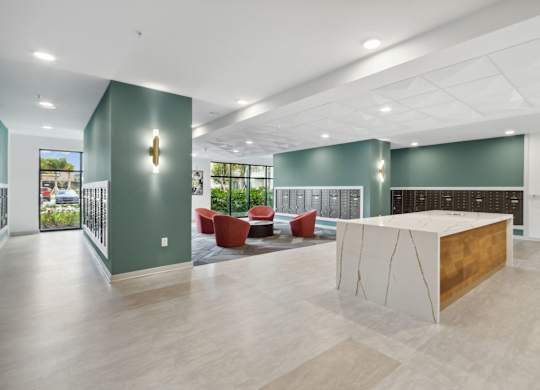 A reception area with a white reception desk and a green wallat Pinnacle Apartments, Jacksonville, FL