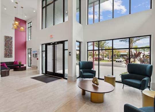 A large room with a pink wall and a glass doorat Pinnacle Apartments, Jacksonville, FL