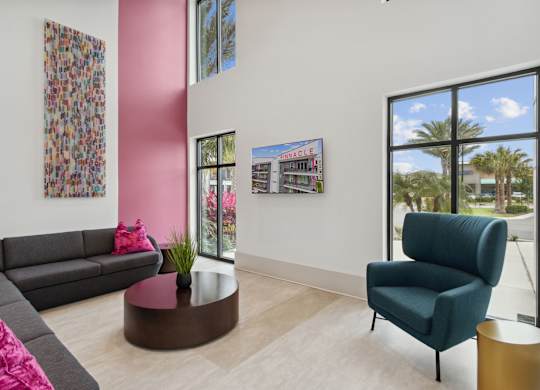 A living room with a grey sofa, a green armchair, and a coffee table.at Pinnacle Apartments, Jacksonville, FL