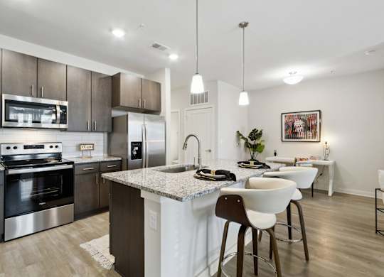A modern kitchen with a large island and stainless steel appliancesat Pinnacle Apartments, Jacksonville, FL