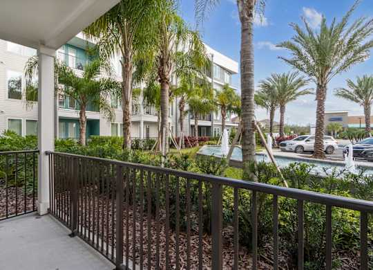 A balcony with a railing and a view of a building and treesat Pinnacle Apartments, Jacksonville, FL