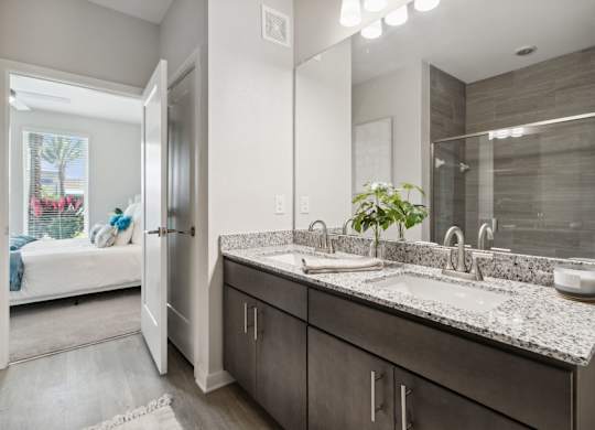 A bathroom with a double sink vanity and a mirror above itat Pinnacle Apartments, Jacksonville, FL