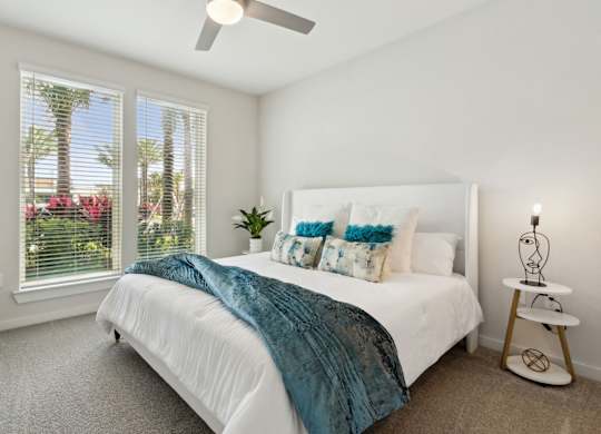 A bedroom with a bed, a fan, and a window with blindsat Pinnacle Apartments, Jacksonville, FL