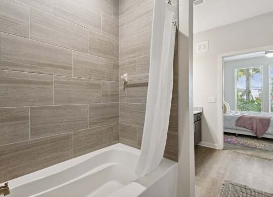 A bathroom with a tub and a windowat Pinnacle Apartments, Jacksonville, FL