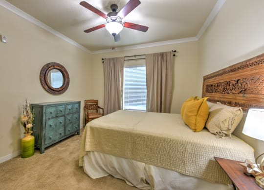 the master bedroom has a large bed and a ceiling fan at Hacienda Club, Jacksonville, FL, 32256