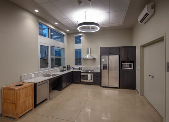 Kitchen in Community room with stainless steel appliances and dark cabinets
