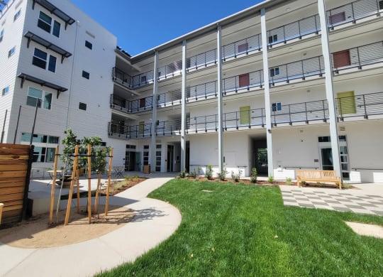 Courtyard at Lavender and interior of building with 4 stories, walkways, and green space.