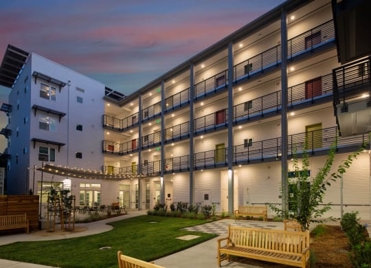 Courtyard at night with walkway lights illuminating the 4 story building.