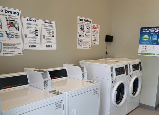 Laundry room at Lavender with two washing machines and dryers and a folding table.