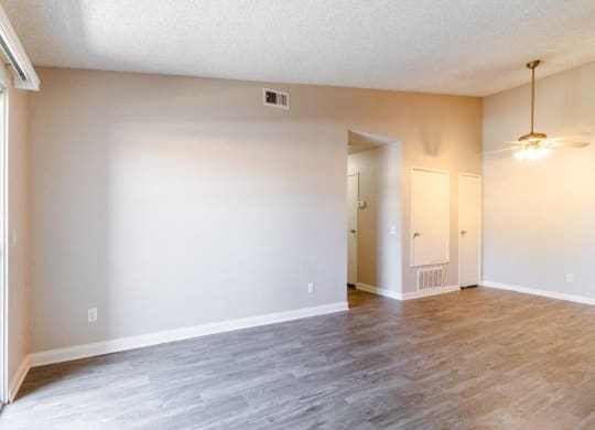 an empty living room with white walls and a wood floor