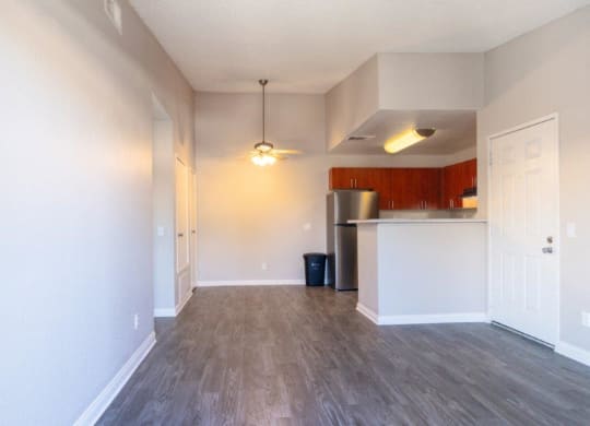 an empty living room and kitchen with wood floors