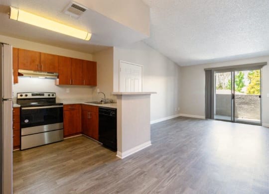 an empty kitchen and living room with a sliding glass door